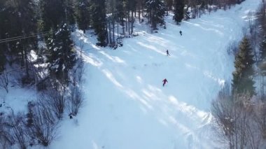  4k. Hava. Kış döneminde dağlar tepeler. Ski lift kayakçı siluetleri ile