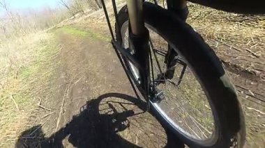 Tekerlekli bisiklet lastik ile toprak yolda gidiyor. Ağır çekim, bisikletçi gölgesi