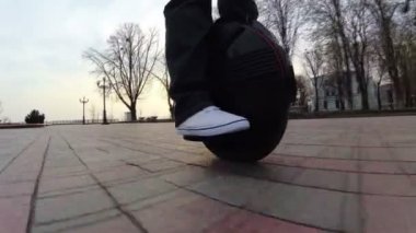 4k. Elektrik şehir ulaşım. Adam beyaz ayakkabı mono tekerlekli sürme 