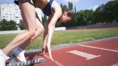 Genç atlet kız stadyum bloğundan koşmaya başladı. Yavaş çekim, sabit çekim, arka görüş