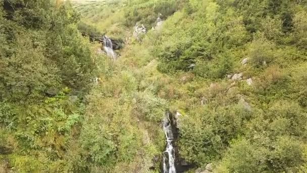 Aérien. Vol au ralenti au-dessus de petites chutes d'eau dans les collines de montagne. Beauté de la nature 