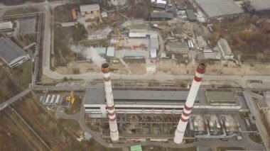 4k .Aerial. Endüstriyel alanda beyaz dumanlı borular. Amera eğiliyor.