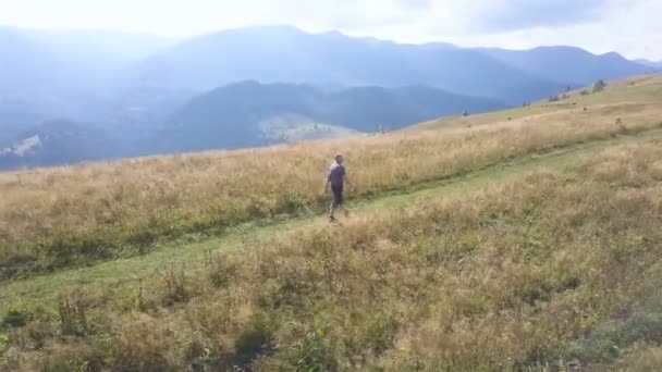 4K航空旅行チーム 大人の男の周りを飛ぶ観光客は山の領域で尾根に行く — ストック動画