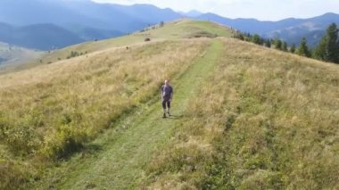 4k .Aerial. Yetişkin turistlerin etrafında uç dağ yamacına çık. Seyahat ekibi.