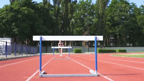 Female Athlete Track Young Runner Stadium Jump Barriers Slow Motion — Stock Video
