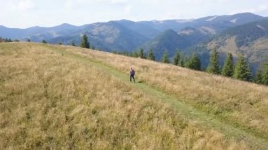 4k Aerial seyahat ekibi. Autumn Mountain Hill 'de sırt sırtında gezen bir adam. Uç.