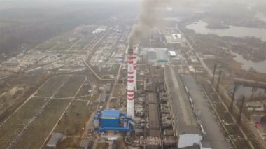 4k .Aerial. Kasvetli bir günde boruları ve dumanı olan sanayi bölgesi. Eski elektrik santrali havayı kirletiyor