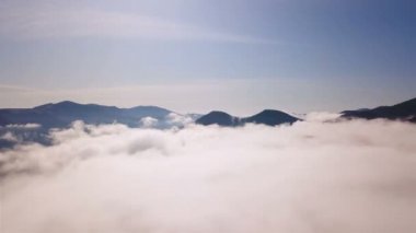 4K .Aerial beautiful l landscape . Smooth fly over mountains clouds ,ridges and hills. Blue sky