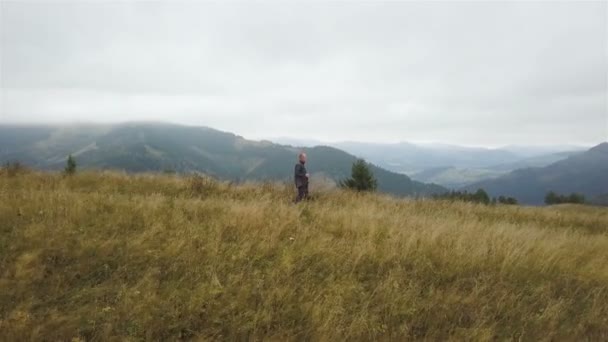 Aerial 旅行中の生活 棒付きの男の観光客は山の丘の尾根に行く — ストック動画
