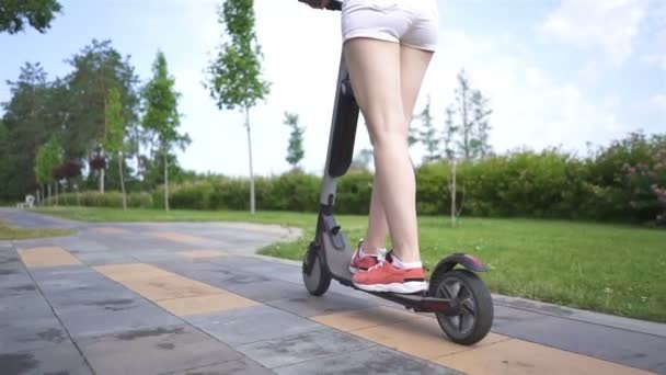 Piernas Niña Montando Scooter Eléctrico Zona Del Parque Ciudad Disparo — Vídeo de stock