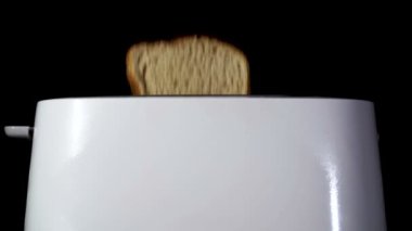          Kızarmış ekmekli beyaz ekmek kızartma makinesi. Ağır çekim, yemek takımı, yaklaşın.