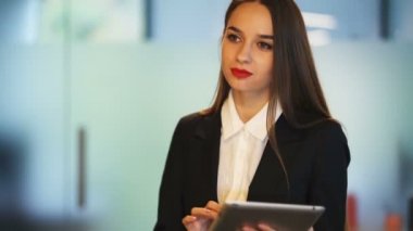 4. Çekici genç iş kadını ofiste tablet ile yürümek . Sabit atış