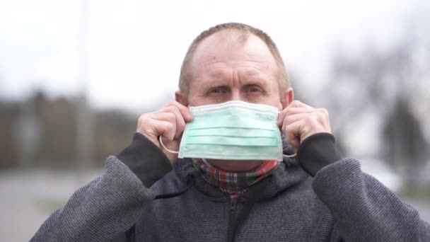 Virusproblemteamet Kaukasisk Man Tar Sig Medicinsk Mask Och Tittar Kameran — Stockvideo