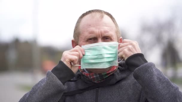 Starszy Biały Mężczyzna Zakłada Maskę Medyczną Patrzy Kamerę Portret Bliska — Wideo stockowe