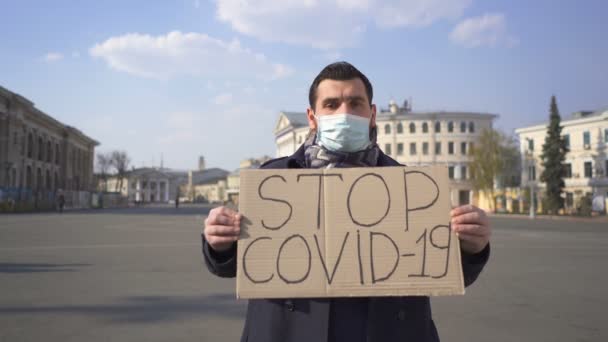 Nowoczesny Mężczyzna Masce Medycznej Prosi Powstrzymanie Epidemii Covid Plakatem Ulicy — Wideo stockowe