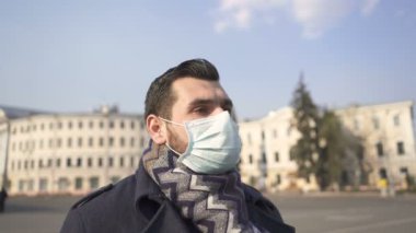 Sağlık maskeli beyaz adam şehir caddesine çıkıyor. Portait, salgın ekibi 