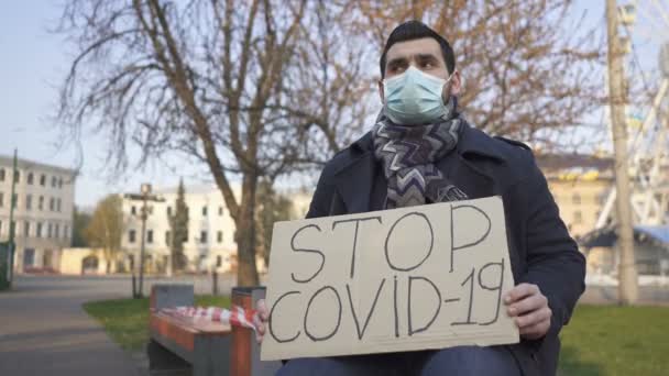 Equipa Pandémica Homem Máscara Médica Sentar Banco Com Cartaz Rua — Vídeo de Stock