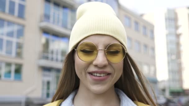Joven Chica Sonriente Gorra Amarilla Gafas Pie Área Mirando Cámara — Vídeos de Stock