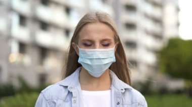 Salgın ekibi. Uzun saçlı genç kadın şehir sokaklarında maske takıyor.. 