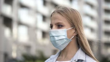 Şehir caddesinde maskeli genç bir kadın. Portait, salgın ekibi