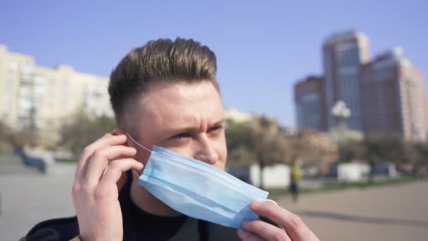 Junger Moderner Mann Setzt Medizinische Maske Auf Der Leeren Straße — Stockvideo