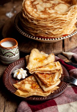 Krep yiyecekler. Tabakta bir yığın ince krep. Rus gözleme haftası. Sular yükseldi. Kıtır kıtır olmuş ince krep. Ev yapımı hamur işleri. Kahvaltıda krep. Aperatif yemek..