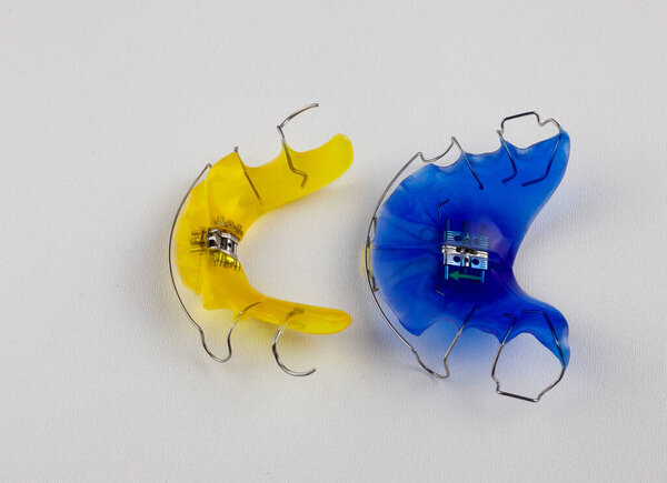 Зубные пластины на верхней и нижней челюсти - альтернатива мозолям для зубов с вытянутыми зубами. Зубные протезы ортодонтов. Ортодонтия. Стоматологические плиты изолированы на белом фоне
.