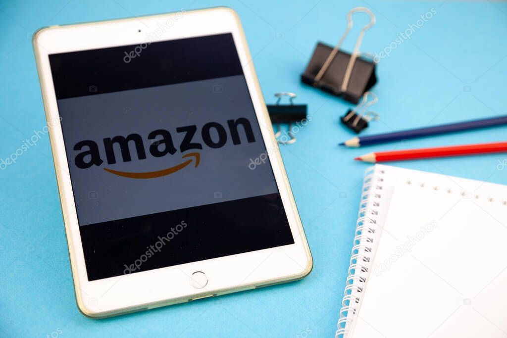 Amazon website logo on a gadget. Desktop mockup. Notebook, pens, pencil, record, work remotely, make an order.