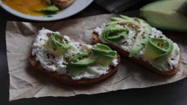 Stilleven - avocado toast. Broodjes voor het ontbijt op een bord op tafel. Voedsel. — Stockvideo