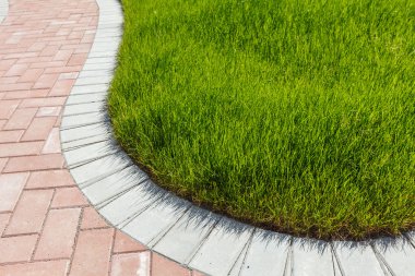 Tuğla geçit ve yeşil çimen 