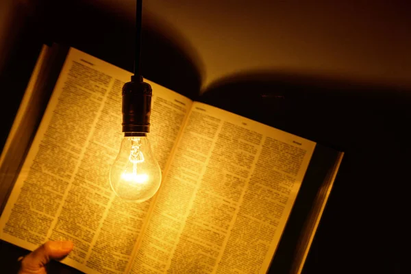Ampoule électrique illuminant un livre — Photo