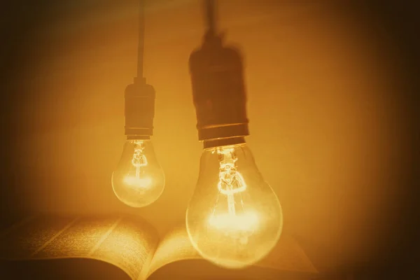 Bombilla eléctrica que ilumina un libro — Foto de Stock