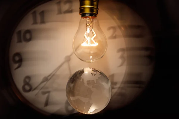 Light bulb, earth and clock — Stock Photo, Image