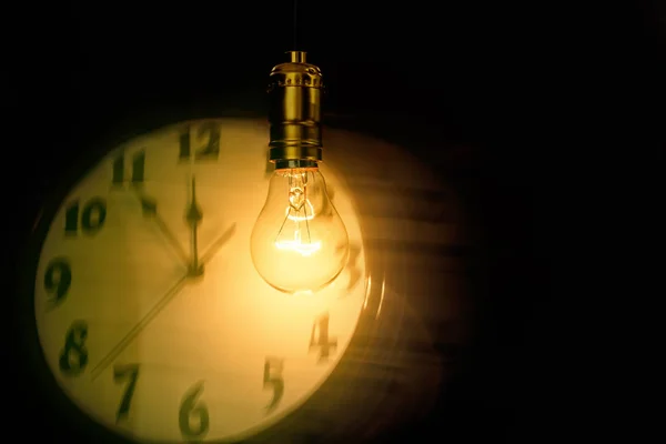 Light bulb and clock — Stock Photo, Image