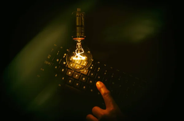 Light bulb and computer keyboard — Stock Photo, Image