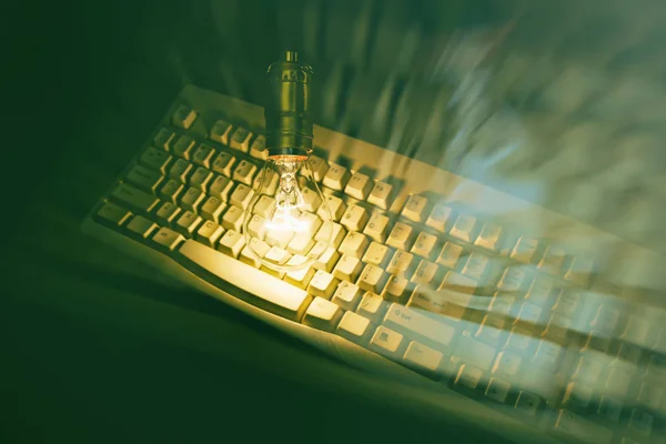 Light bulb and computer keyboard — Stock Photo, Image