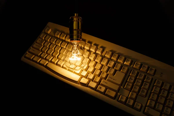 Lâmpada e teclado do computador — Fotografia de Stock