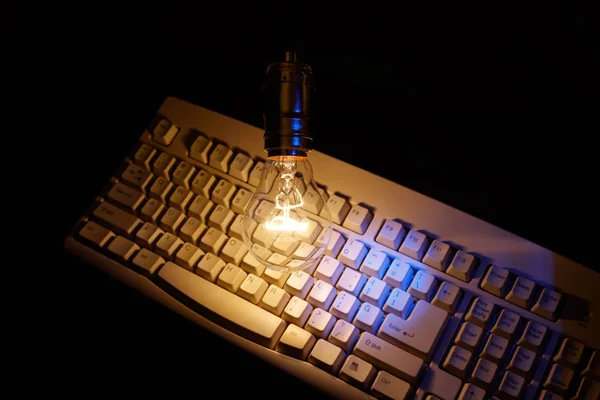 Gloeilamp en toetsenbord van de computer — Stockfoto