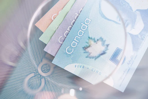 Dólar canadense e lupa — Fotografia de Stock