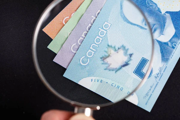 Canadian dollar and magnifying glass — Stock Photo, Image