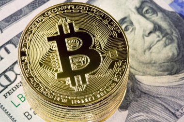 Yüz dolar faturaları arka plan üzerinde metal bitcoin paralar.