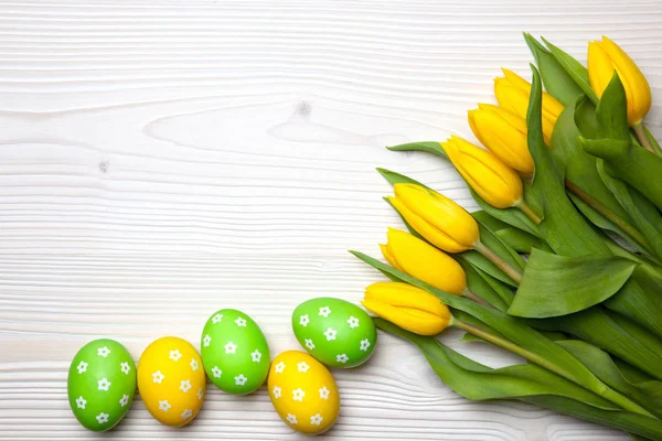 Uova di Pasqua e tulipani su sfondo di legno. — Foto Stock