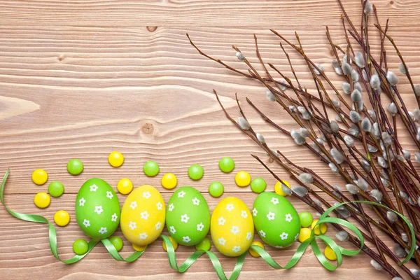 Ovos de Páscoa e ramos de salgueiro no fundo de madeira . — Fotografia de Stock