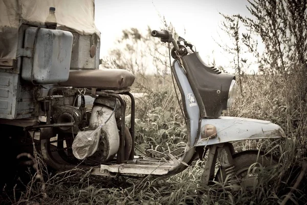 An old truck scooter standing in field in summer. Low color saturation for a faded retro or vintage effect — Stock Photo, Image