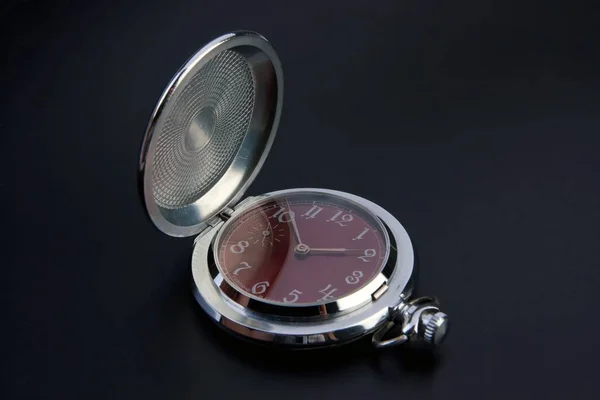 Isolated photo of opened silver pocket watch with red clock face in the black background — Stock Photo, Image