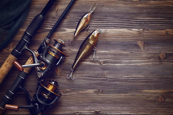 Aparejos de pesca - spinning de pesca, anzuelos y señuelos en bac de madera —  Fotos de Stock