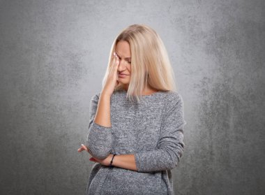 Kadın üzgün bir yüz ile. Gri bir arka plan üzerinde.