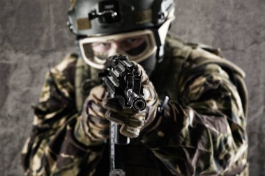 Özel Kuvvetler asker gri arka plan üzerinde silahlı.