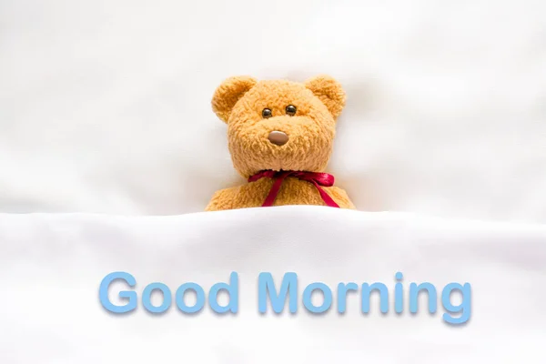 Teddy Bear lying in the white bed with message " Good morning " — Stock Photo, Image