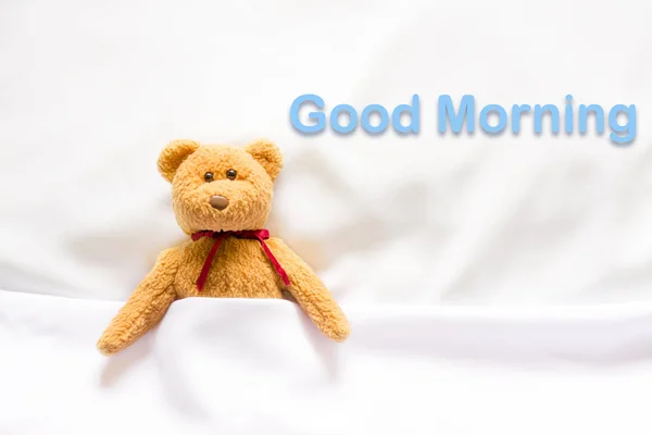 Teddy Bear lying in the white bed with message " Good morning " — Stock Photo, Image